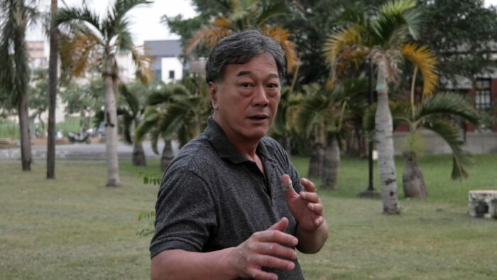 Ho Tsun-Tao a.k.a. Bruce Li in ENTER THE CLONES OF BRUCE (2023). Severin Films. An older Bruce Li strikes a martial arts pose in a park.