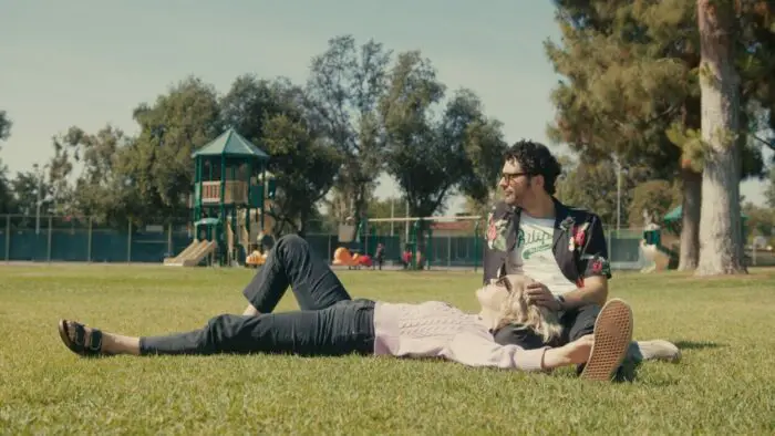 Emily lays in Cooper's lap at a park