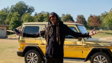 Snoop Dogg stands in front of his gold-plated Mercedes SUV in The Underdoggs.