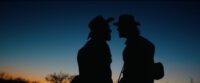Two Civil War soldiers facing each other, silhouetted against a blue sky.