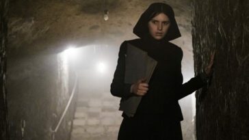 Nell Tiger Free as Margaret in 20th Century Studios' THE FIRST OMEN. Photo by Moris Puccio. © 2024 20th Century Studios. All rights Reserved. Novitiate nun Margaret creeping through a dark underground passage attempting to escape with secret files.