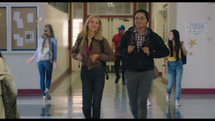 Two teens walk down a high school hallways in The Moon & Back.