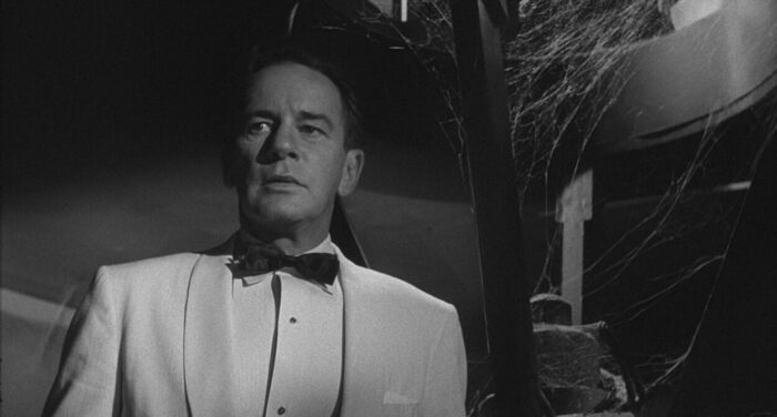 Richard Carlson as Tom Stewart, wearing a tuxedo and looking concerned, in <em>Tormented.</em> 