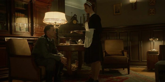 Irena serves a drink to a Nazi officer