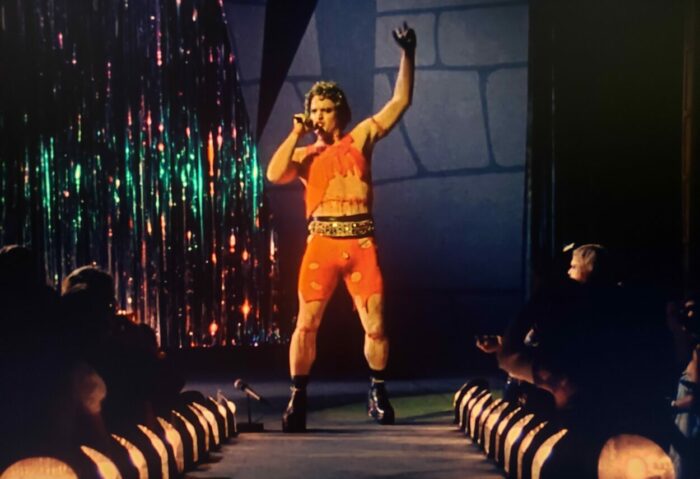 Gerrit Graham as Beef in Phantom of the Paradise (1974). Screen capture off of Amazon. © 20th Century Fox. Frankenstein themed glam rock singer Beef performs on stage.