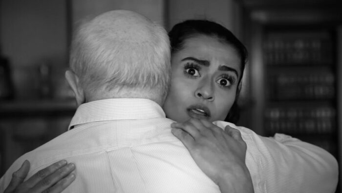 A surprised woman receives a hug.