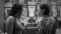 Two women talk on a street in Guy Friends.