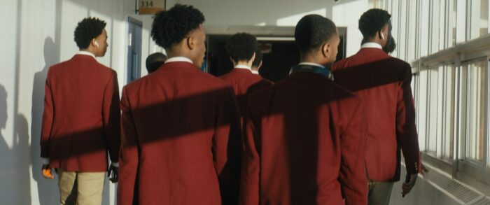 The River Rouge team, shown from behind wearing maroon sport coats for game day.