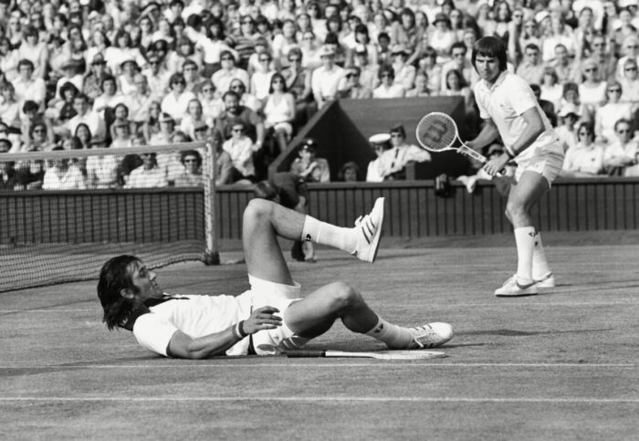 Ilie Nastase clowns as doubles partner Jimmy Connors watches.