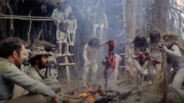 Robert Kerman and Salvatore Basil with uncredited performers as Prof. Monroe and Chaco among the Yąnomamö tribe in Cannibal Holocaust (1980). Screenshot off Peacock. Cannibalistic tribe of the Yąnomamö preparing a body over a roasting fire to serve to Prof. Monroe and his companion Chaco.
