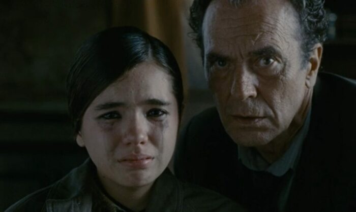 A girl with tears in her eyes and a man looking into the camera.