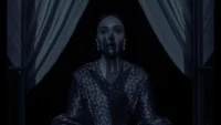 A woman stands at a window and the shadow of a vampires hand appears on her horrified face