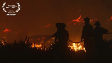 Firefighters carry a hose while battling a raging forest fire in Chile.