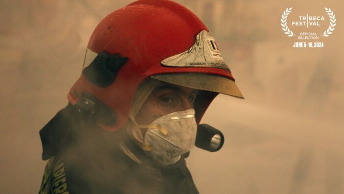 A firefighter wearing a mask turns toward the camera.