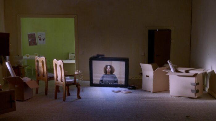 A still from "A Home on Every Floor" depicting a miniature apartment with a television set.