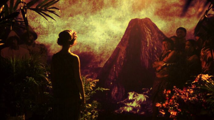A woman looks at a distant mountain and talks to natives in The Forbidden Room by Guy Maddin