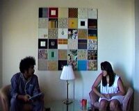Kallia (Artemis Shaw) and Ram (Prashanth Kamalakanthan) engage in discussion while seated in the apartment.