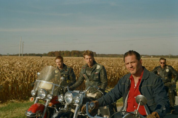 A group of men pose on their motorcycles.