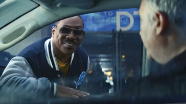 A man in sunglasses smile to people in a car in Netflix's Beverly Hills Cop: Axel F