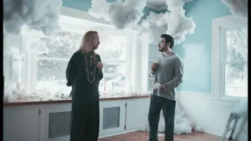 Two men stand in a room decorated with models of puffy clouds in The Secret Art of Human Flight