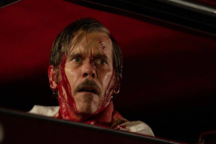 John Labat (Kevin Bacon), covered in blood, looks out in fear.