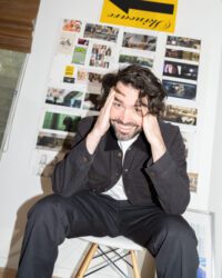 Austin Peters sits on a stool with his hands in his hair