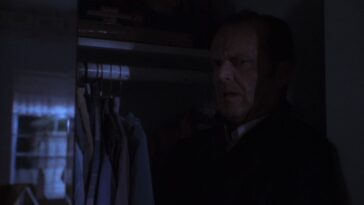 Freddy hides in a closet, his body in silhouette.